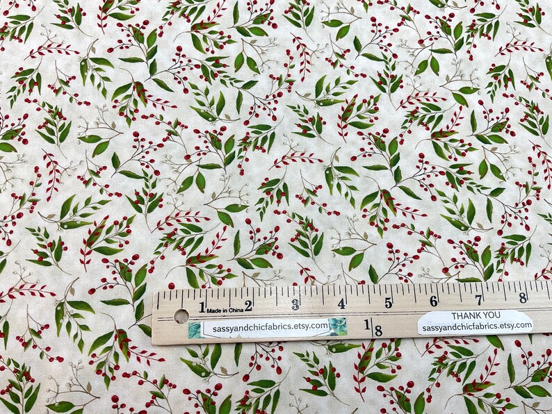 Puede incluir: Tela crema con un patr&oacute;n repetido de hojas verdes y bayas rojas. El dise&ntilde;o incluye tallos finos de color claro. Una regla est&aacute; colocada sobre la tela, con el texto "Made in China" y el nombre de la tienda Etsy visibles.