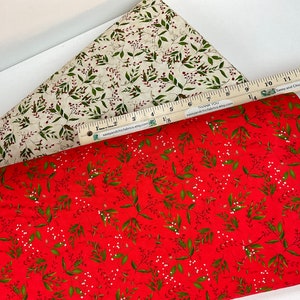 Puede incluir: Dos muestras de tela con estampados bot&aacute;nicos. Una es roja con hojas verdes y bayas blancas, la otra es crema con acentos verdes y rojos similares. Una regla con texto se coloca sobre las telas.