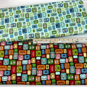 May include: Two rolls of fabric with a retro kitchen appliance pattern. One fabric is light blue with green and blue designs. The other fabric is dark brown with colorful designs. A ruler is placed on top of the fabric.