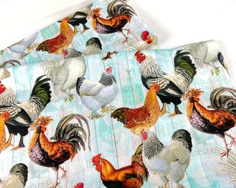 May include: Two pieces of fabric with a repeating pattern of colorful roosters and hens. The roosters are in shades of brown, red, black, and white. The background has a light blue, wood-grain design. The word "LUCKERS" is visible in the background.