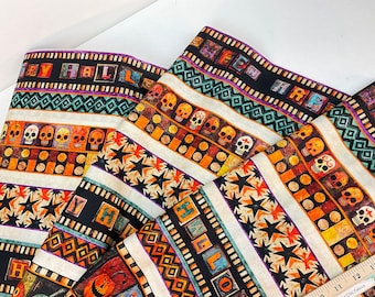 May include: Halloween-themed fabric with repeating patterns. The design includes skulls, stars, and the words "HAPPY HALLOWEEN" in a block letter style. The fabric has a black, orange, and cream color scheme.