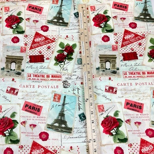Może przedstawiać: Tkanina o tematyce paryskiej z czerwonymi r&oacute;żami, ilustracjami wieży Eiffla i wzorami poczt&oacute;wek. Tkanina zawiera tekst taki jak "Paris" i "Carte Postale". Drewniana linijka jest umieszczona na tkaninie.