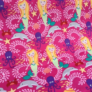 May include: A vibrant pink fabric featuring a repeating pattern of mermaids, dolphins, octopuses, crabs, seashells, and starfish. The mermaids have blonde hair and green tails. White leafy vines and bubbles fill the background.