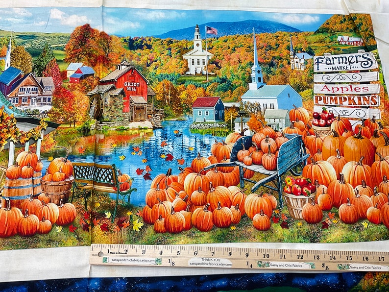Op de afbeelding: Stofpaneel met een levendige herfstsc&egrave;ne met een korenmolen, pompoenen en een boerenmarkt bord. De afbeelding bevat een rivier, gebouwen en een blauwe lucht. Op het bord staat "Appels" en "Pompoenen".