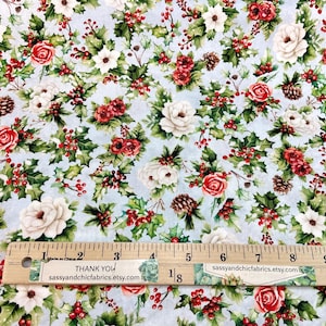 K&ouml;nnte beinhalten: Hellblauer Stoff mit einem Blumenmuster aus roten Rosen, wei&szlig;en Bl&uuml;ten, gr&uuml;nen Stechpalmenbl&auml;ttern und roten Beeren. Ein Holzlineal mit Zentimetermarkierungen und Text liegt auf dem Stoff. Der Text auf dem Lineal lautet "THANK YOU" und "sassyandchicfabrics.etsy.com".