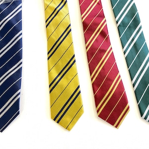 May include: Four neckties in various colors: navy blue with white stripes, yellow with navy stripes, burgundy with gold stripes, and green with white stripes. The ties are arranged on a white surface.