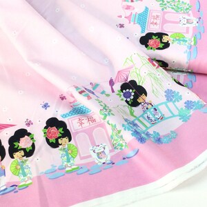 May include: Pink fabric with a repeating Japanese-themed pattern. The design features cartoon geishas, pagodas, bridges, and butterflies. The fabric has a light pink background with a darker pink border.