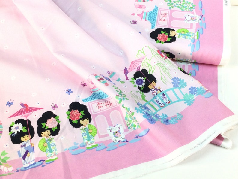 May include: Pink fabric with a repeating Japanese-themed pattern. The design features cartoon geishas, pagodas, bridges, and butterflies. The fabric has a light pink background with a darker pink border.