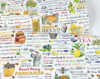 Op de afbeelding: Witte stof met een kleurrijk honing- en bakthema. De stof heeft illustraties van honingpotten, citroenen, bijen en receptinstructies. Tekst bevat "Honey Bread" en "Sweet Honey Pancakes".