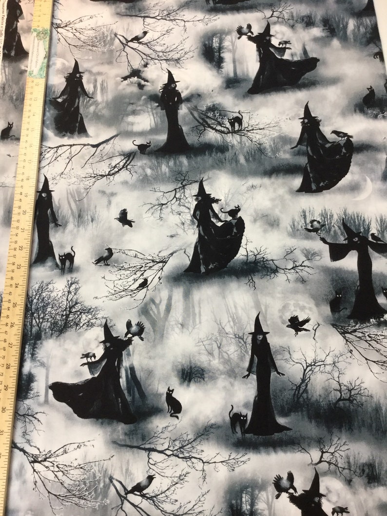 May include: Black and white fabric featuring a repeating pattern of witches in long dresses and pointed hats, with black cats, crows, and bare tree branches against a misty forest backdrop. The design has a spooky, Halloween theme.