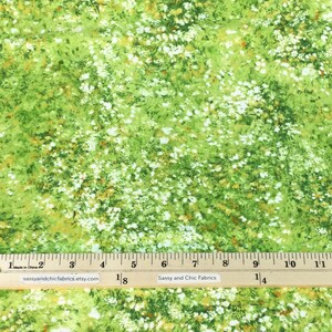 May include: Green fabric with a floral pattern featuring white and orange accents. The fabric has a ruler along the bottom edge, with the text "Sassy and Chic Fabrics" and the website address. The fabric is suitable for various sewing projects.