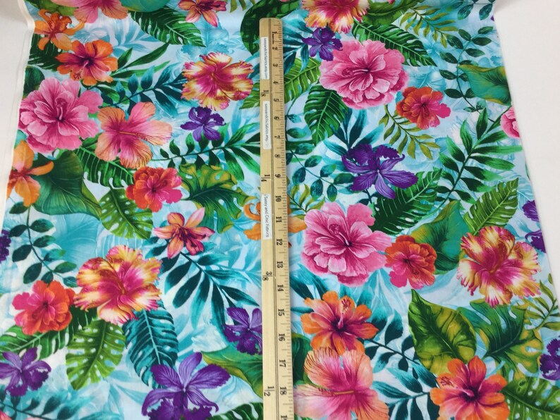 May include: Vibrant floral fabric featuring large pink, orange, and purple hibiscus flowers and tropical leaves on a light blue background. The fabric is decorated with a ruler that measures up to 19 inches.