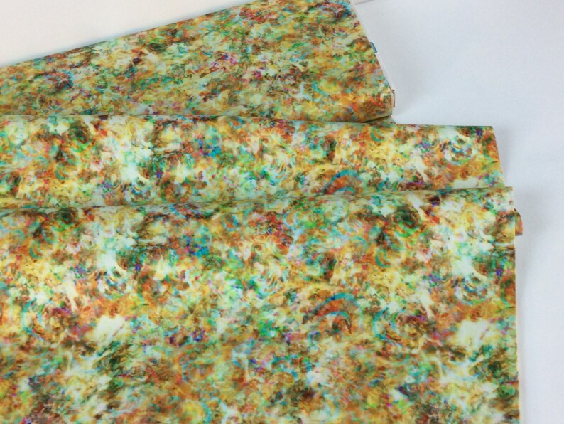 May include: A folded fabric with a colorful, abstract pattern. The design features a mix of colors including yellow, green, brown, orange, blue, and red. The fabric appears to be a lightweight material.
