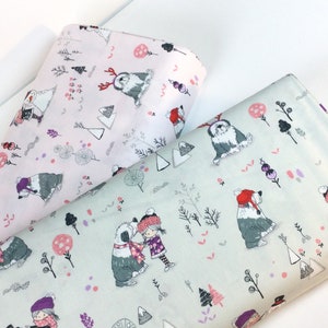May include: Two rolls of fabric with a winter-themed pattern. One roll is light pink, the other is light green. The pattern features Old English Sheepdogs, children, trees, and other winter elements in shades of gray, pink, purple, and red.