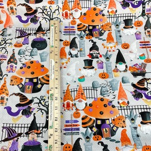 May include: Halloween-themed fabric featuring gnomes, pumpkins, witch hats, and mushrooms in orange, purple, and black on a light gray background. Includes text that reads "Happy Halloween" and "Trick or Treat".
