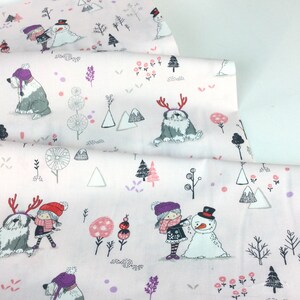 May include: Light pink fabric with a winter-themed pattern. The design features illustrations of children, snowmen, dogs with antlers, trees, and mountains in shades of gray, pink, and purple. The fabric is folded, showing multiple layers.