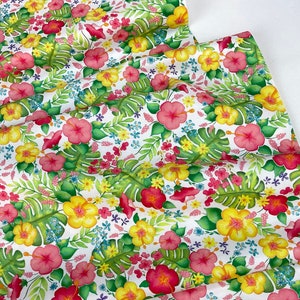 May include: White fabric with a vibrant floral pattern featuring pink, yellow, and red hibiscus flowers, green monstera leaves, and small blue and pink blossoms. The design is a watercolor style, creating a tropical theme.