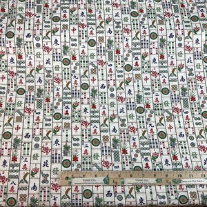 May include: White fabric with a repeating pattern of Mahjong tiles, featuring Chinese characters, flowers, and bird illustrations in red, green, and brown. A ruler with the text "THANK YOU" is visible.