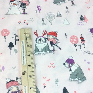 May include: Light pink fabric with a repeating pattern of Old English Sheepdogs, girls, snowmen, and trees. The dogs wear antler headbands and hats. The girls wear hats and scarves. The fabric is decorated with pink, purple, and gray elements.