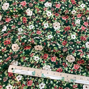 K&ouml;nnte beinhalten: Gr&uuml;ner Stoff mit floralem Muster aus roten Rosen, wei&szlig;en Bl&uuml;ten und Beeren. Auf dem Stoff befindet sich ein Lineal mit dem Text "THANK YOU" und "Sassy and Chic Fabrics". Ideal f&uuml;r N&auml;h- und Bastelprojekte.