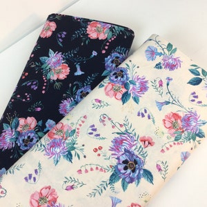 May include: Two rolls of floral fabric. One is navy blue with pink, purple, and blue flowers. The other is off-white with the same floral pattern. The fabric features detailed botanical illustrations.