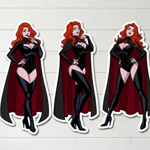 May include: Three die-cut vinyl stickers featuring a cartoon character with long red hair, wearing a black bodysuit, black thigh-high boots, and a black cape with a deep red lining. The character is depicted in three distinct poses, each showcasing the same outfit and a red gemstone brooch at the neck.