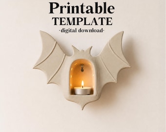 May include: A beige bat-shaped wall sconce featuring a central arched niche holding a lit tea light candle. The text above reads ceramixis, Printable TEMPLATE, and digital download. The design includes detailed wing structures and a smooth finish.