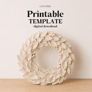 May include: A circular wreath made of off-white ceramic leaves and small berries. The text above the wreath reads: ceramixis Printable TEMPLATE digital download. The design features a repeating pattern of pointed leaves arranged in a ring.