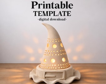May include: A beige ceramic witch hat lamp with a curved tip and a wide brim featuring a buckle detail. The hat has circular cutouts of varying sizes that emit a warm, glowing light. Text above reads ceramixis Printable TEMPLATE digital download.