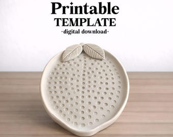 May include: A light beige ceramic dish shaped like a fruit with two leaves at the top and a textured surface featuring small circular indentations. The text above reads ceramixis Printable TEMPLATE digital download.