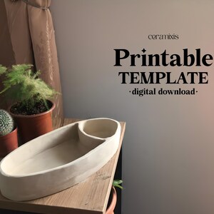 May include: A cream-colored, oval-shaped planter with a built-in small round section. The planter is on a wooden surface, with small potted plants to the left. The image includes the text "Printable TEMPLATE - digital download-".