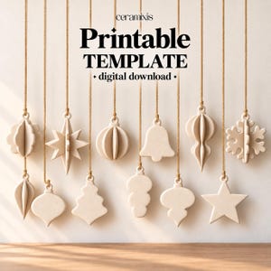 Peut inclure: Une collection de douze ornements suspendus tridimensionnels blanc cassé de formes variées, incluant des étoiles, des cloches et des flocons, suspendus par de fines ficelles beiges. Le texte "ceramixis Printable TEMPLATE digital download" est centré.