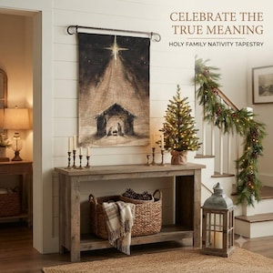 May include: A rectangular wall tapestry featuring a dark, sepia-toned illustration of a nativity scene under a bright star. The text CELEBRATE THE TRUE MEANING HOLY FAMILY NATIVITY TAPESTRY is printed in the upper right corner of the image.