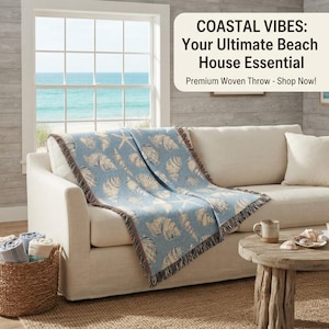 May include: A light blue woven throw blanket featuring a repeating pattern of white seashells and starfish, draped over a beige sofa. The text on the image reads: COASTAL VIBES: Your Ultimate Beach House Essential. Premium Woven Throw - Shop Now!