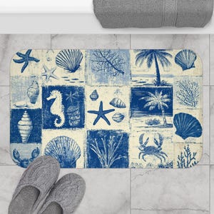 May include: A rectangular bath mat with a blue and cream coastal design. The mat features a patchwork pattern with images of seashells, starfish, seahorses, and palm trees. Gray slippers are at the bottom.