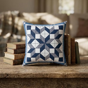 Peut inclure: Un coussin carré arborant un motif géométrique en étoile bleu et blanc. Le design se compose de triangles bleu marine unis et de carrés blancs, agrémentés d'un imprimé floral bleu et blanc détaillé. Le coussin présente une fine bordure bleue.