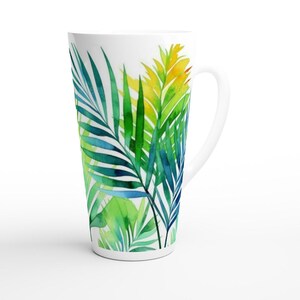 May include: White ceramic mug with a watercolor design of green, blue, and yellow palm leaves.
