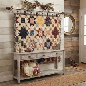 May include: A rectangular wooden console table with three drawers and a lower shelf, featuring a hanging quilt with a star pattern suspended from a metal rod with pinecone finials, decorated with greenery, lights, and a woven basket of textiles.