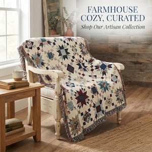 Könnte beinhalten: Eine gewebte Wohndecke mit einem mehrfarbigen Stern- und geometrischen Steppmuster in Burgunderrot, Marineblau und Creme, drapiert über einem weißen Holzstuhl. Der Text FARMHOUSE COZY, CURATED Shop Our Artisan Collection ist sichtbar.