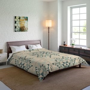 May include: A bed with a dark wooden frame and a comforter featuring a geometric pattern in shades of teal and beige. The room has white walls, a brown rug, and a painting on the wall.