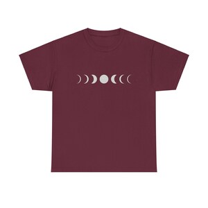 Könnte beinhalten: Ein maroonfarbenes T-Shirt mit einer weißen Grafik des Mondes in verschiedenen Phasen.