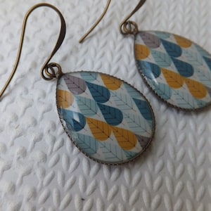 Turquoise Pale Blue Taupe and White Print Resin Earrings hung from tall french antique bronze long earring hooks