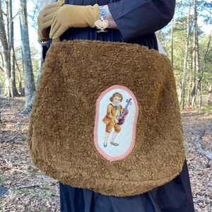 Bolso de hombro holgado confeccionado con tejido de lana de osito de peluche, dos bolsillos grandes en el lateral, bordado vintage de niño violín