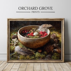 Könnte beinhalten: Gerahmter Kunstdruck mit einem Stillleben. Eine rustikale Schale mit roten Beeren, Moos und einer Feder liegt auf grünem Moos. Tannenzapfen und der Text "ORCHARD GROVE PRINTS" sind ebenfalls zu sehen.