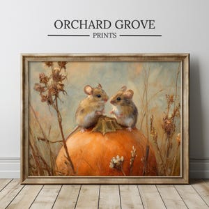 Puede incluir: Impresión artística enmarcada que presenta dos ratones pequeños posados sobre una gran calabaza naranja. La obra de arte tiene un estilo vintage con una paleta de colores cálidos de naranja, marrón y beige. El texto "ORCHARD GROVE PRINTS" se muestra en la parte superior.