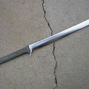 May include: A long, silver blade with a black and gray handle. The blade is sharp and pointed, and the handle is textured. The blade is about 30 inches long.