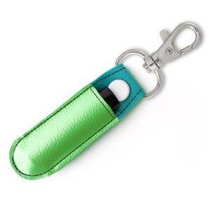 May include: A green and blue fabric keychain with a silver clip. The keychain has a pocket for a lip balm or other small item.