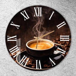 May include: A round wall clock featuring a photographic print of a steaming cup of coffee on a saucer surrounded by coffee beans. The clock face displays large white Roman numerals and has thin gold-colored hour, minute, and second hands.