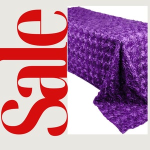 May include: Purple satin tablecloth with a rose pattern. The tablecloth is made of a soft, luxurious fabric and is perfect for adding a touch of elegance to any event.