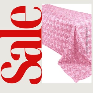 May include: A pink satin tablecloth with a rose pattern. The tablecloth is 108 inches long and 54 inches wide.